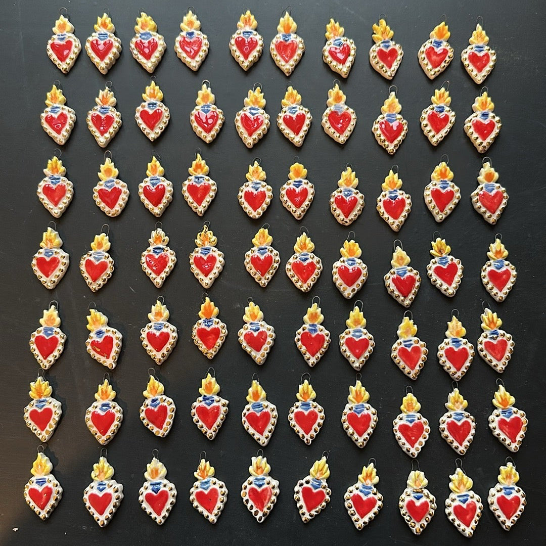 Heart-shaped embellishments with red centers and gold accents on a dark surface